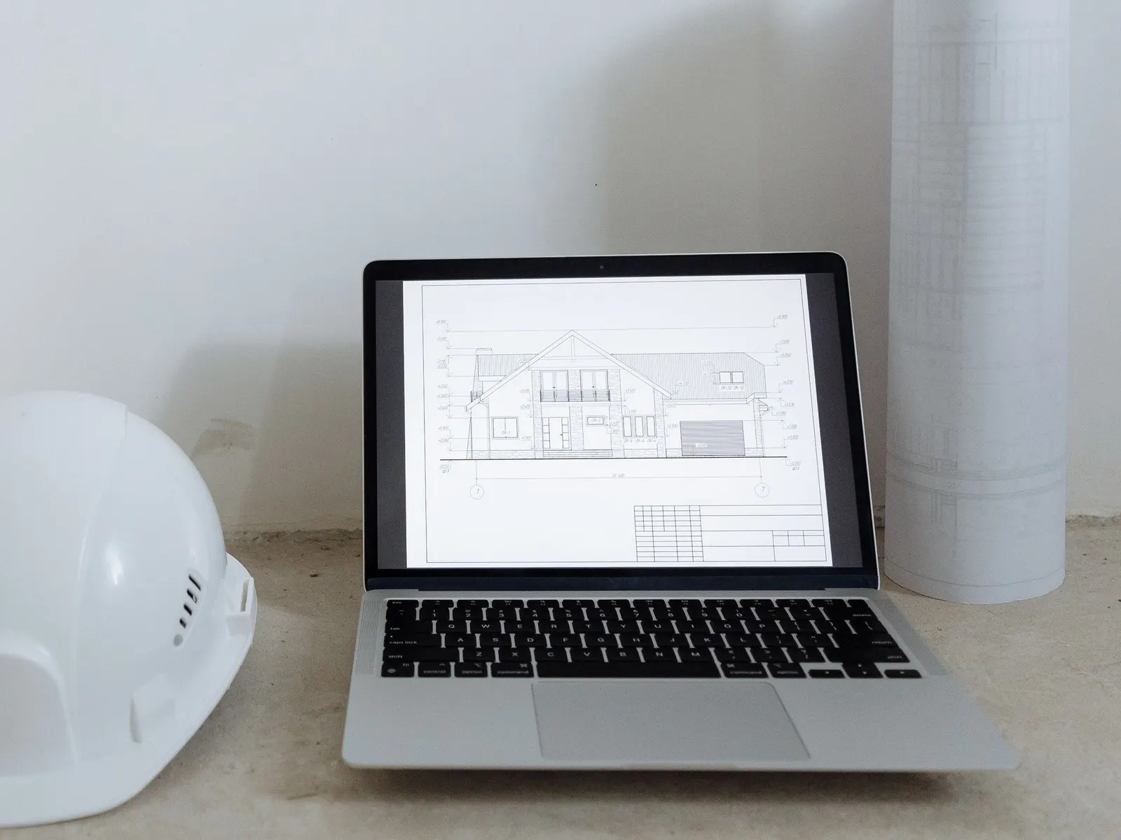 Exemple de site web d'une entreprise de rénovation affiché sur un ordinateur portable, à côté d'un casque de chantier